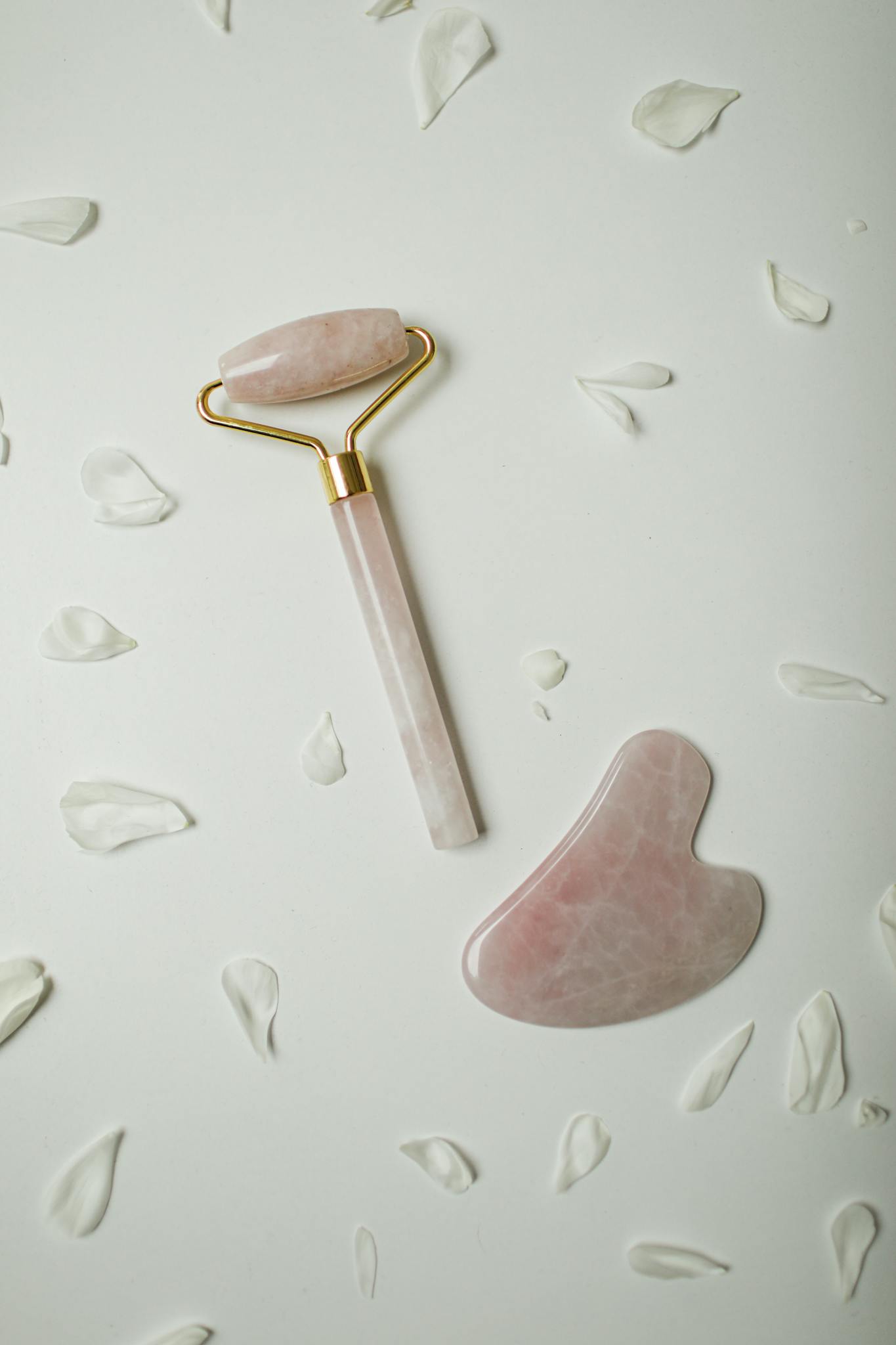 Close-up of a rose quartz face roller and gua sha stone, perfect for luxurious facial care.